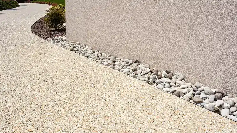 New PStone carpet path next to a building wall with white river stones