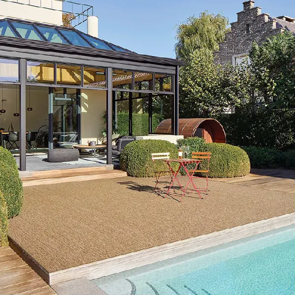 brown textured outdoor rug on a wooden deck next to a pool