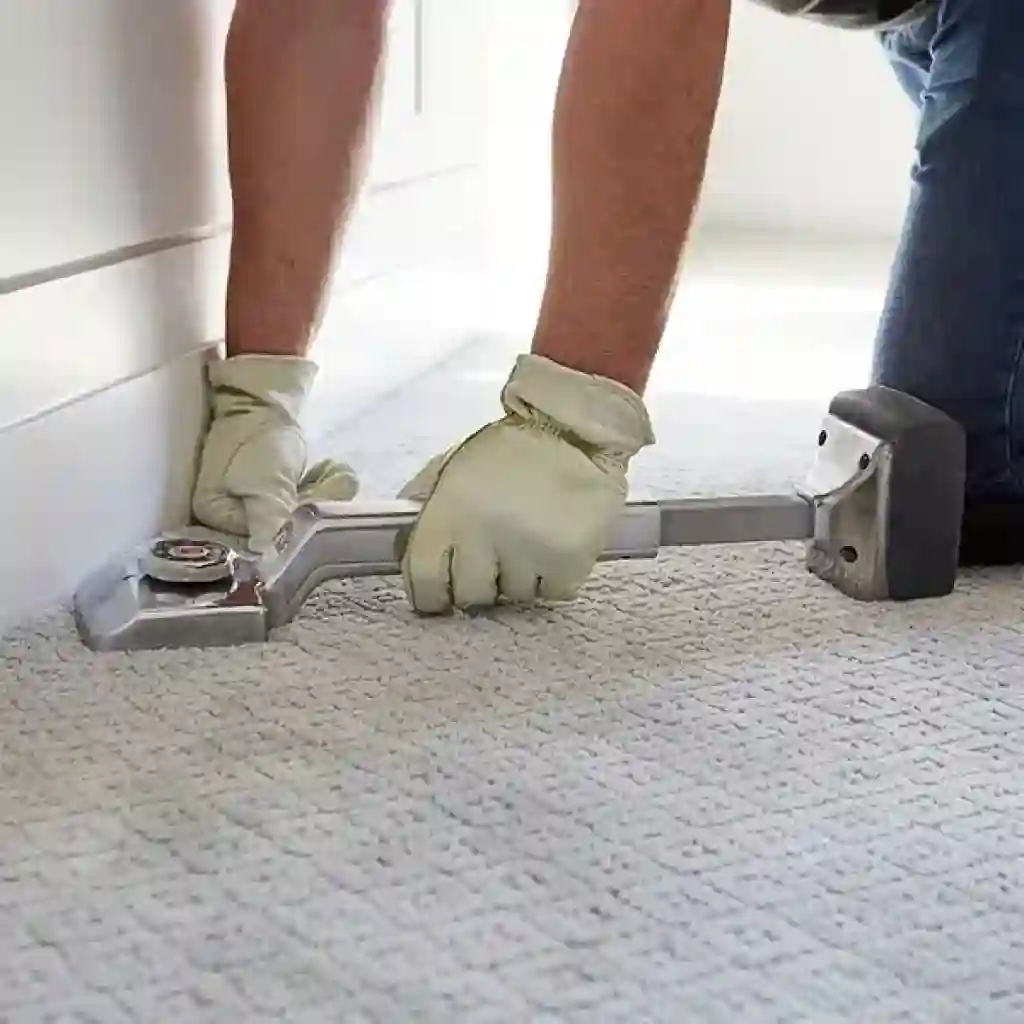 Carpet Installation 11 using a power stretcher on a light-colored, patterned carpe