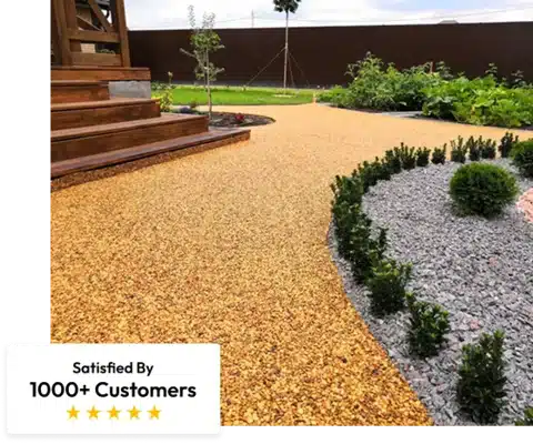 golden yellow stone carpet walkway leading past a landscaped area