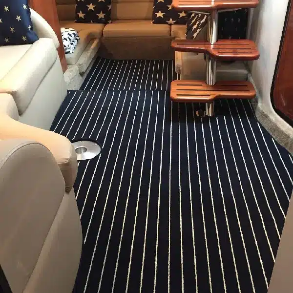 Dark blue boat carpet with white vertical stripes installed in a boat cabin
